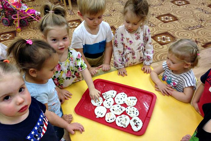 Воспитатель объясняет, как дети украшают фасолью и горохом пирожки.